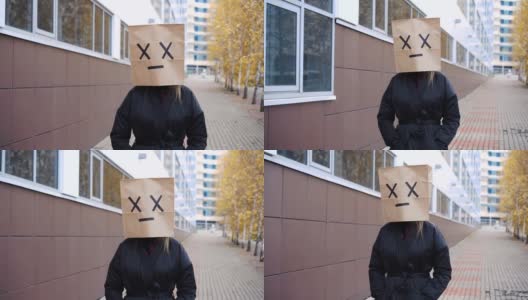 沮丧害怕的纸袋脸走在街上。女人戴着面包袋和x交叉眼睛高清在线视频素材下载