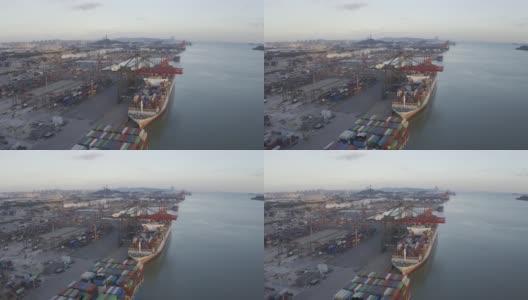 夕阳下，几艘大型货轮停在港口装卸集装箱。高清在线视频素材下载
