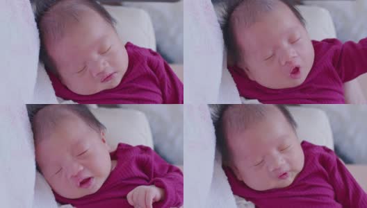 可爱的睡着的新生儿放松在妈妈的手臂安全舒适。微笑亚洲新生儿宝宝休息睡觉香甜的梦。母亲抱着婴儿。新生儿摄影概念高清在线视频素材下载