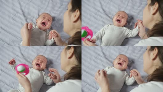年轻的母亲试图平息大哭的男婴高清在线视频素材下载
