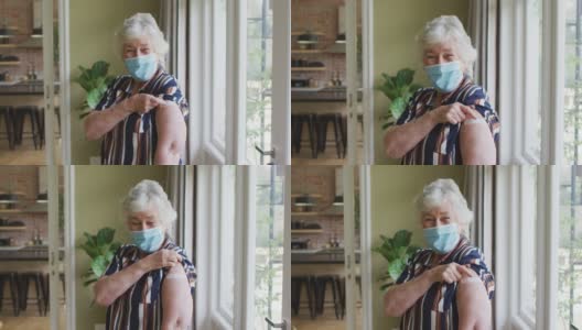 一名白人老年妇女戴着口罩，向人们展示她接种过疫苗的肩膀高清在线视频素材下载