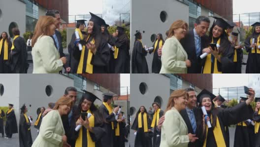 毕业典礼后，一名快乐的女学生和父母一起用智能手机自拍高清在线视频素材下载