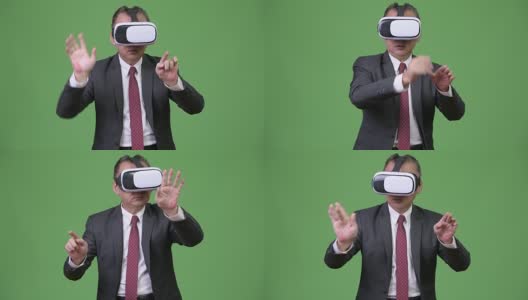 成熟的日本商人在绿色背景下使用虚拟现实头盔高清在线视频素材下载