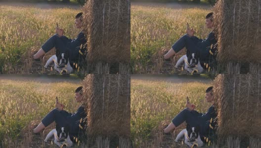 吉尔在草地上，法国斗牛犬拿着智能手机。高清在线视频素材下载