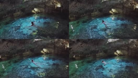 游客们在阿克屯陈坑的绿松石地下水池中游泳高清在线视频素材下载