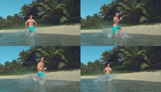 慢镜头:快乐的人在浅海中奔跑，溅起周围的水高清在线视频素材下载