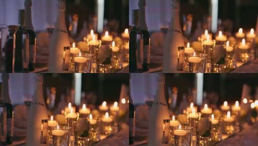 婚礼宴会厅的内部细节与装饰餐桌设置在餐厅。蜡烛和白色花瓣装饰玫瑰花在玻璃花瓶装满水高清在线视频素材下载