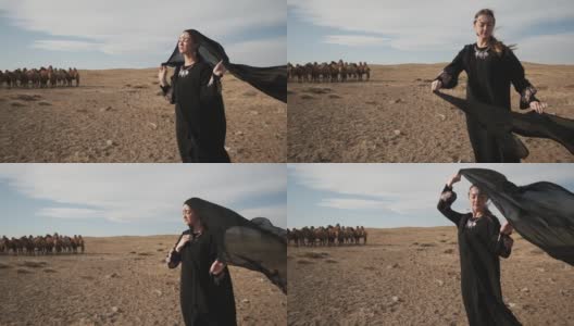 美丽的女子民族黑衣服，阿拉伯长袍走草原骆驼，沙漠，缓慢高清在线视频素材下载