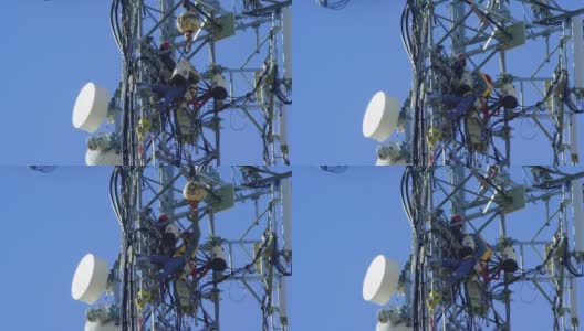 特写的两个技术人员更新一个手机塔在一个晴朗，阳光明媚的日子高清在线视频素材下载
