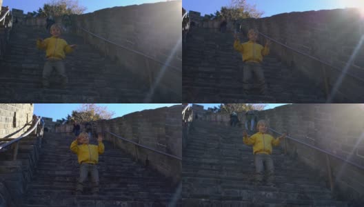 一个快乐的小男孩在中国长城的楼梯上玩的慢镜头高清在线视频素材下载