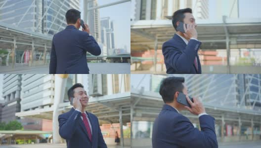 亚洲经理聪明的商人使用智能手机在城市。那人拿着电话，一边说话，一边微笑着站在户外。以电信和移动网络为经营理念。高清在线视频素材下载