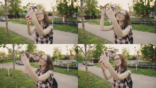 年轻迷人的女人在眼镜与樱花自拍高清在线视频素材下载