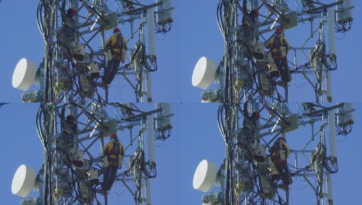 特写的两个技术人员组装一个新的5G手机塔在一个晴朗，阳光明媚的日子高清在线视频素材下载