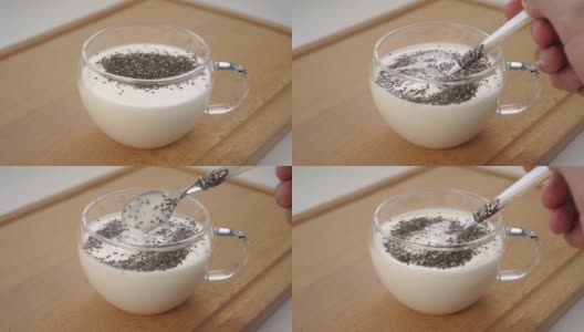 将开菲尔或酸奶与奇亚籽混合在玻璃杯中高清在线视频素材下载