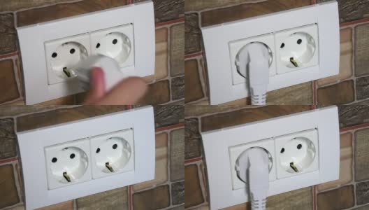 女人用手从墙上的电源插座上插拔插头。高清在线视频素材下载