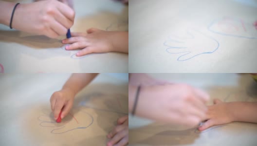 手绘孩子的手的轮廓。孩子在白纸上画画。高清在线视频素材下载