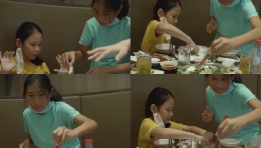 快乐3亚洲女孩与家人一起在餐厅吃素喜烧、涮涮锅或火锅，生活方式理念。高清在线视频素材下载