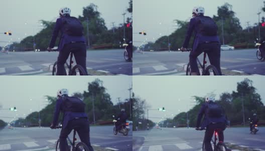 晚上下班后骑自行车回来的亚洲男人。他在红绿灯前停了下来高清在线视频素材下载