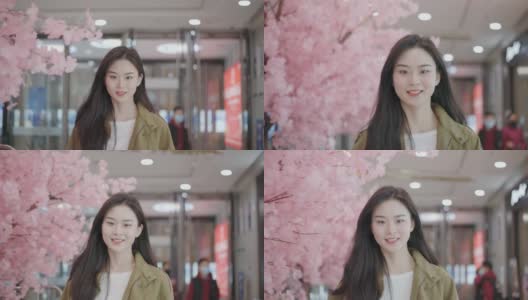 年轻美丽的中国女性正在购物，她们留着长长的棕色头发，对着镜头微笑着高清在线视频素材下载