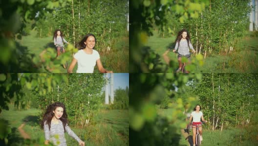 绿树成荫的树枝，姑娘们嘻嘻哈哈地骑着自行车，绿树成荫，阳光灿烂的夏日高清在线视频素材下载