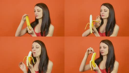 漂亮的褐发年轻女人手握黄香蕉，然后吃它在明亮的橙色背景。热带水果。夏天的概念。健康饮食。高清在线视频素材下载