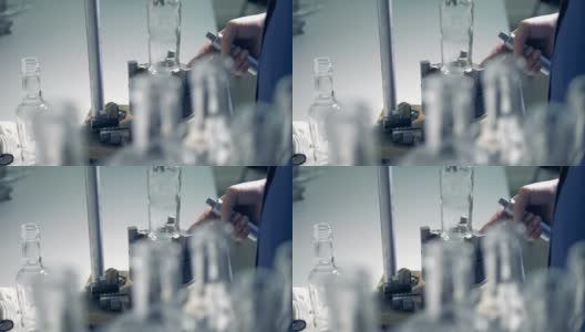一名工人正在旋转一个放在金属支架上的玻璃瓶子高清在线视频素材下载