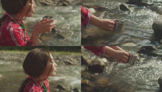 特写女性的手装满旅行杯从山溪的冷水高清在线视频素材下载