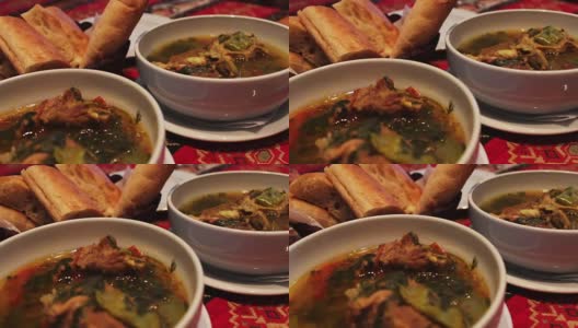 美味的阿塞拜疆民族羊肉汤在餐厅。以面包玉米饼为背景的白色盘子里的肉汤高清在线视频素材下载