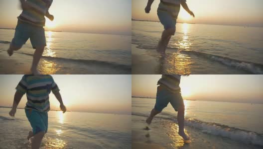 Barefoot kid running in sea water at sunset高清在线视频素材下载
