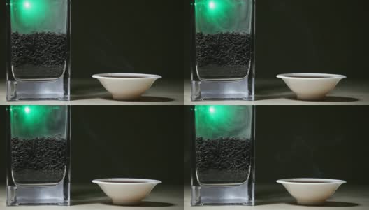 黑热的中国茶杯，绿色的烟，木桌，黑色的背景，没有人高清的画面高清在线视频素材下载