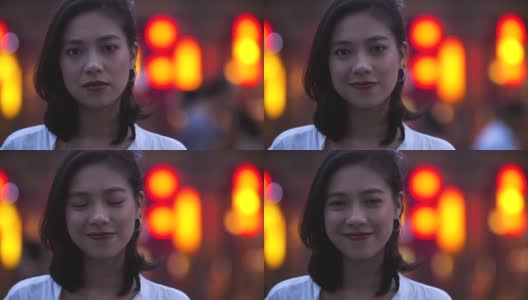 年轻的亚洲女人在晚上对着相机微笑的肖像高清在线视频素材下载