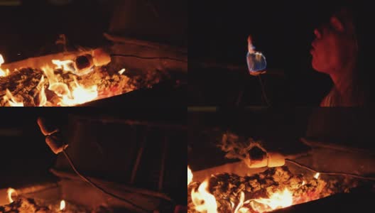 近距离拍摄的女孩烤棉花糖在一个舒适的篝火上使用棍棒。棉花糖着火了，她把它们吹灭了。用RED摄像机拍摄，慢动作。高清在线视频素材下载