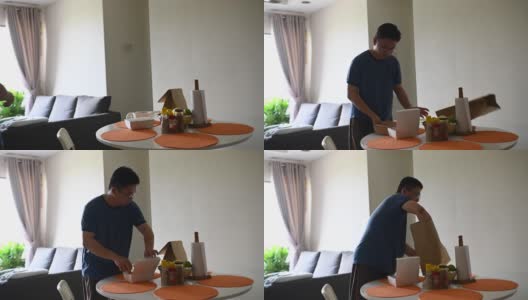 一名亚洲华人中年男子在冠状病毒隔离期间呆在家里享用中餐午餐盒饭高清在线视频素材下载
