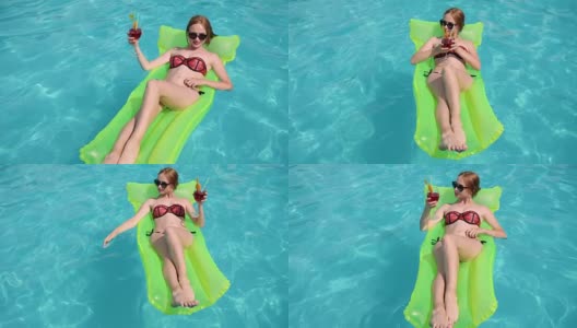 水派对，女孩在比基尼躺在充气海滩床垫到泳池边，女性在游泳衣与五颜六色的鸡尾酒在手里高清在线视频素材下载