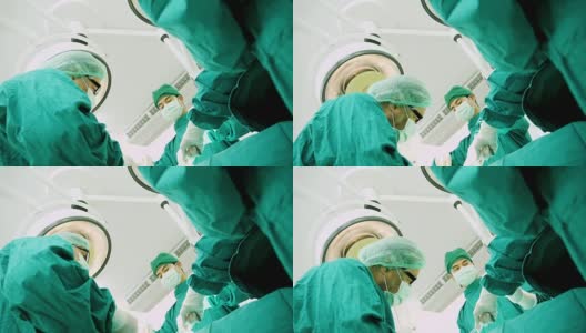 多民族外科手术组穿着防护服在医院手术室进行手术，医疗队在现代手术室进行手术。高清在线视频素材下载