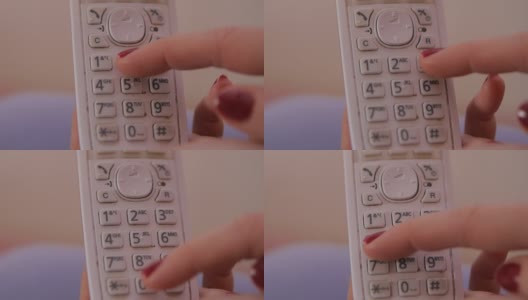 女性用红指甲握着座机，拨着电话号码。高清在线视频素材下载