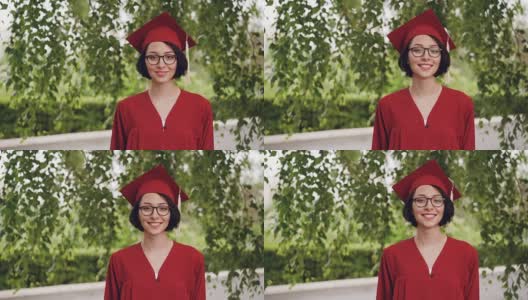 这是一幅快乐的年轻女毕业生的照片，她穿着学士服，面带微笑地站在校园的树下。青年教育理念。高清在线视频素材下载