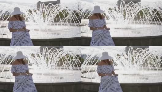 一位戴着帽子的中年妇女坐在喷泉旁边写字。高清在线视频素材下载