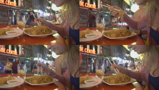 特写:饥饿的年轻女子挣扎着用木筷子吃面条高清在线视频素材下载