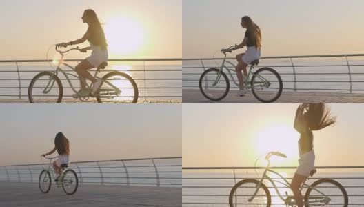 年轻迷人的女人骑着老式自行车在海边日出或日落高清在线视频素材下载