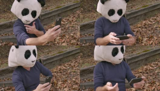 一名男子戴着熊猫头面具用智能手机自拍并分享高清在线视频素材下载