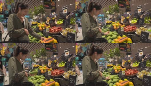 美丽的年轻女子购买水果和蔬菜在农产品部门高清在线视频素材下载