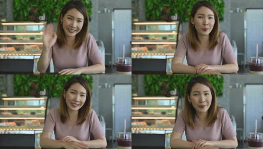 一名亚洲妇女在咖啡店的视频会议中对着摄像机说话高清在线视频素材下载