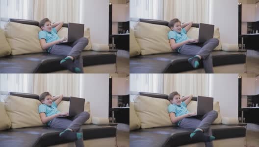 小男孩在隔离期间在家看有趣的电影。青少年坐在家里舒适的沙发上，孩子和小玩意概念。高清在线视频素材下载
