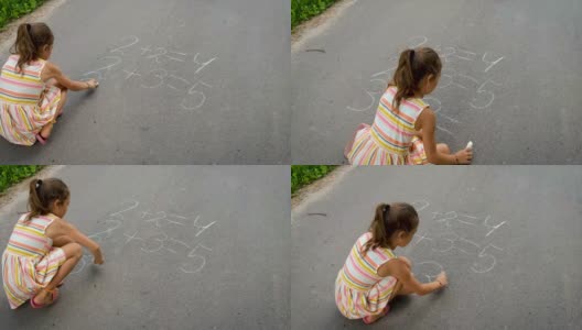 孩子在柏油马路上写方程式。有选择性的重点。高清在线视频素材下载