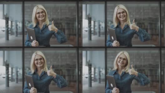 商务女性，在办公室里手拿笔记本电脑，竖起大拇指高清在线视频素材下载