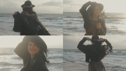 在秋天的日落或日出时，浪漫的黑发女人戴着帽子和皮夹克在海滩上散步高清在线视频素材下载