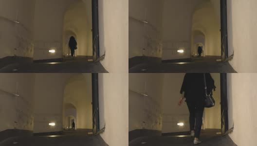 晚上一个女人在狭窄的过道上行走高清在线视频素材下载