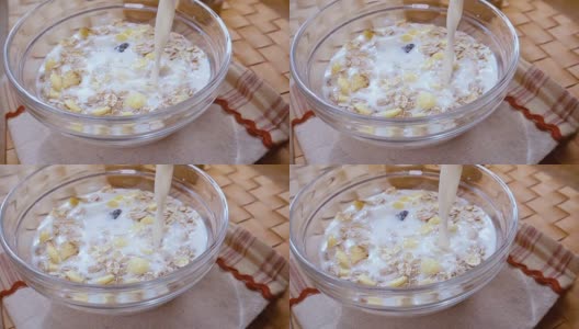 全谷物麦片早餐在碗里，美味的早餐和牛奶。慢动作旋转跟踪镜头。高清在线视频素材下载