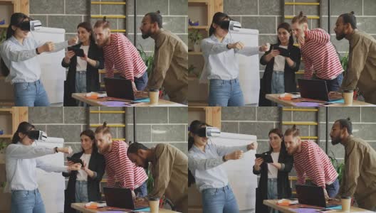 亚洲女孩测试新的赛车游戏模拟器VR耳机与同事控制她的经验与数字平板电脑在初创办公室高清在线视频素材下载